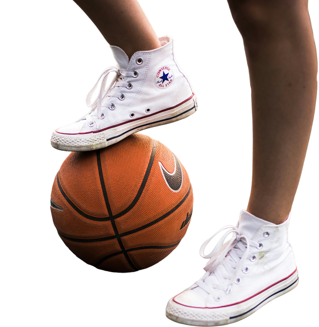 A person is seen standing on a basketball in white shoes